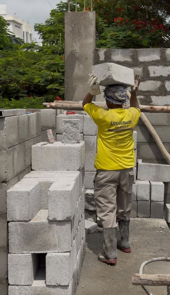 KSM Constructions — Mason carrying concrete block