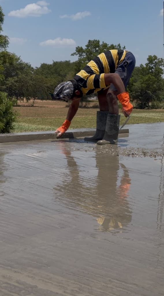 KSM Constructions — Worker leveling wet concrete slab